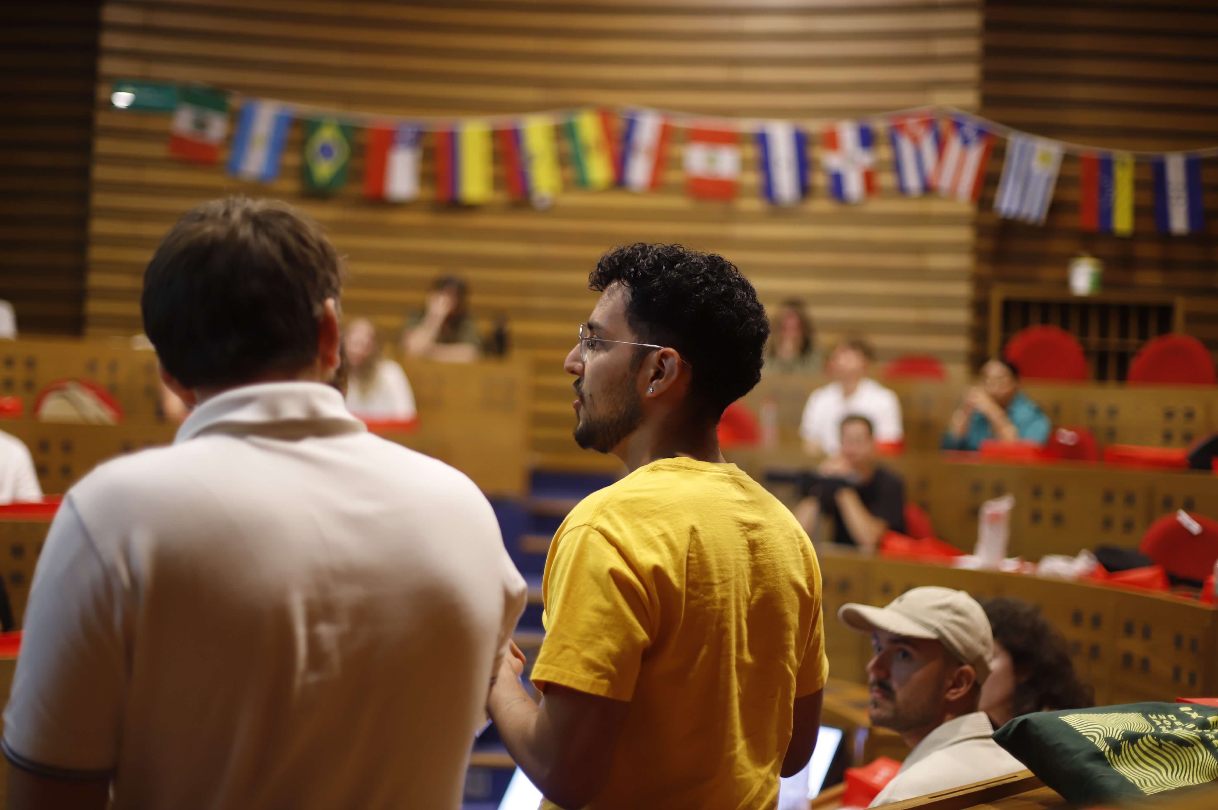 Estudiantes participando en la Semana Internacional, con banderas de distintos países de fondo
